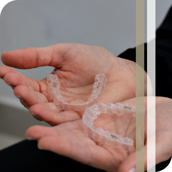 person holding clear aligners
